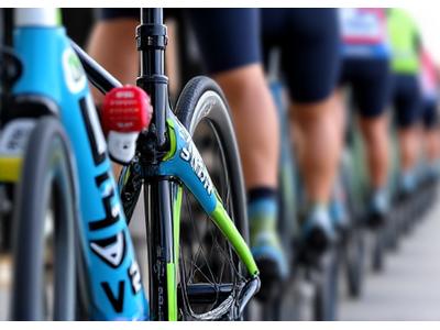 Team of cyclists with matching custom bike team logos on their road bikes